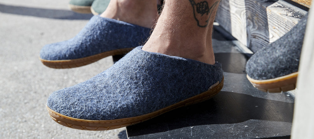 A close up picture of a person wearing glerups slip-ons in the color Denim with natural rubber sole. 