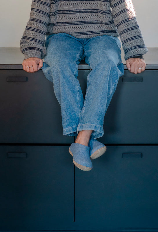 A close up picture of a person's feet wearing glerups slip-ons in the color Sky with calfskin leather sole. 