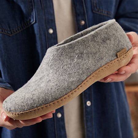 Gray boot with a sole of natural rubber sole held in hands