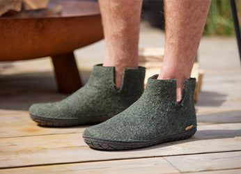 Close up picture of glerups boots in the color Forest green with natural rubber soles in black. 